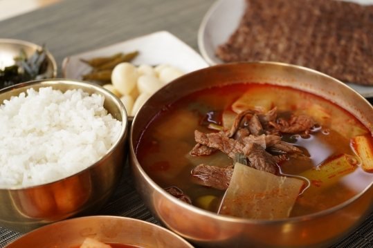 놋쇠 그릇의 한우국밥과 밥, 뒤에 석쇠불고기 접시